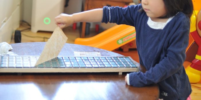 子供がタイルの紙はがし